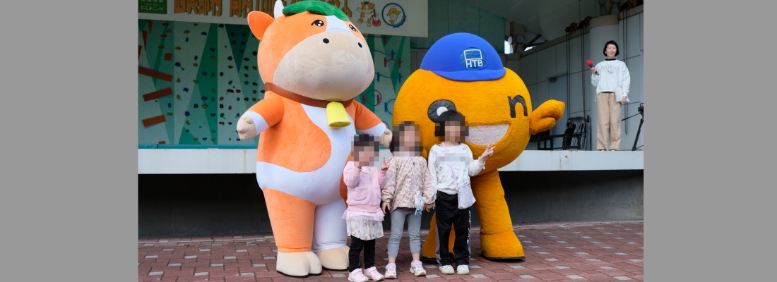 5月ゴールデンウィーク中に開催された森林公園でのイベントの様子。オンちゃんとセトウシくんと女の子3人が笑顔のポーズで写真を撮っている様子。