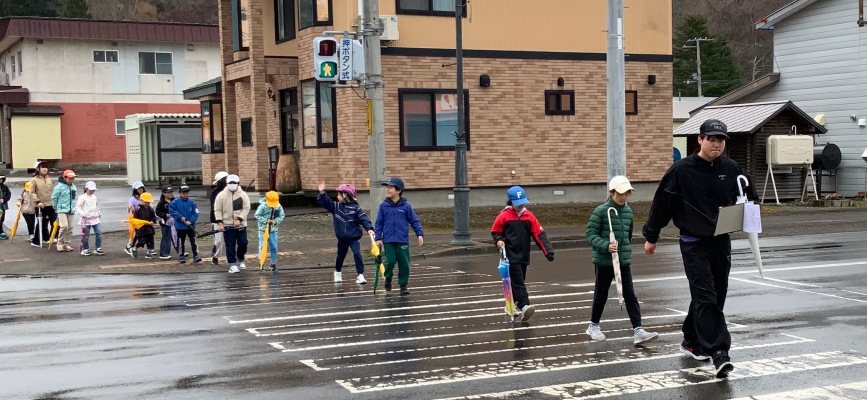 R8年4月21日西小生徒が村内を徒歩で巡り横断歩道の渡し方など交通安全を学習している様子